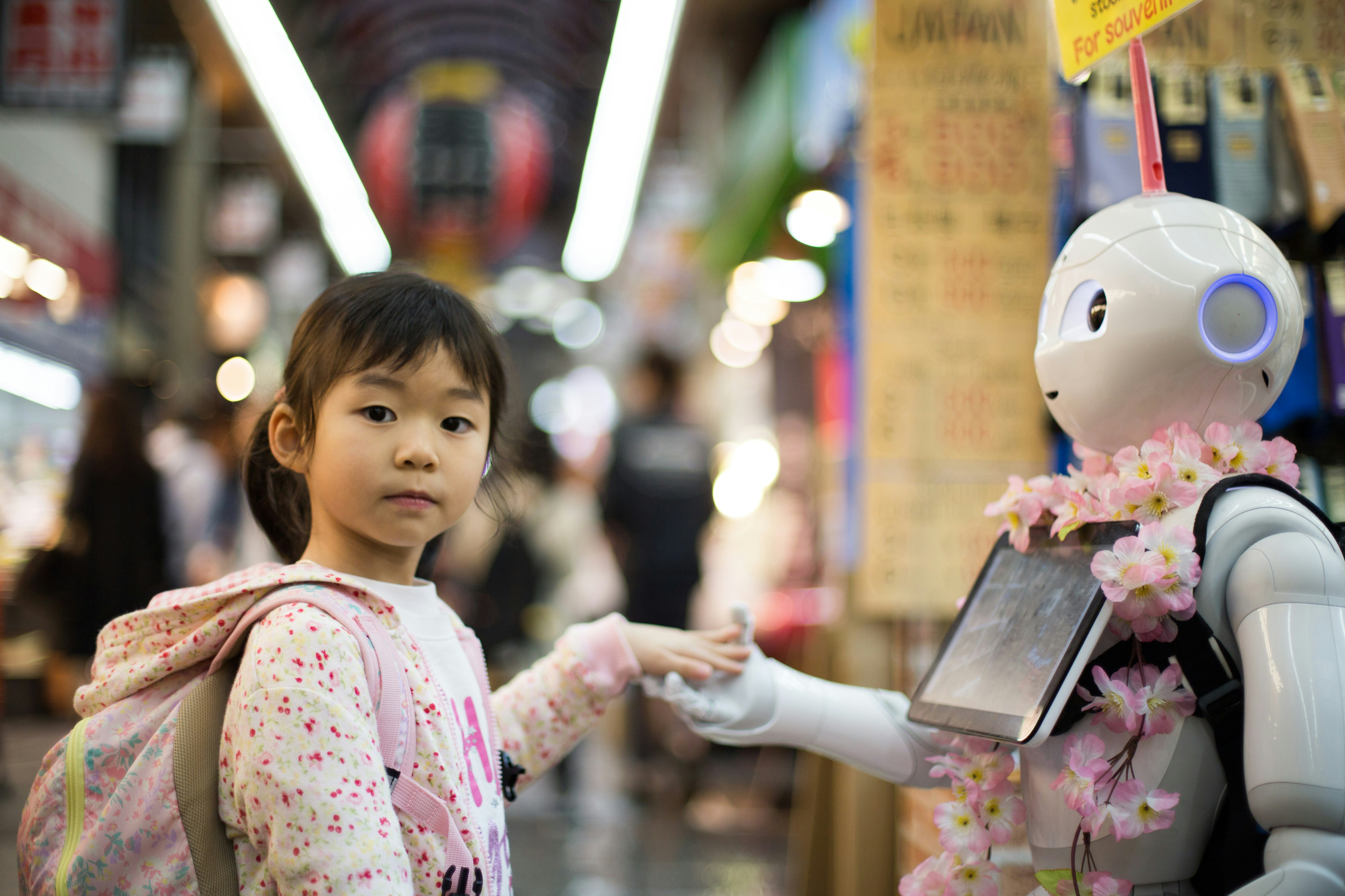 A humanoid robot facing a person in a warm home environment